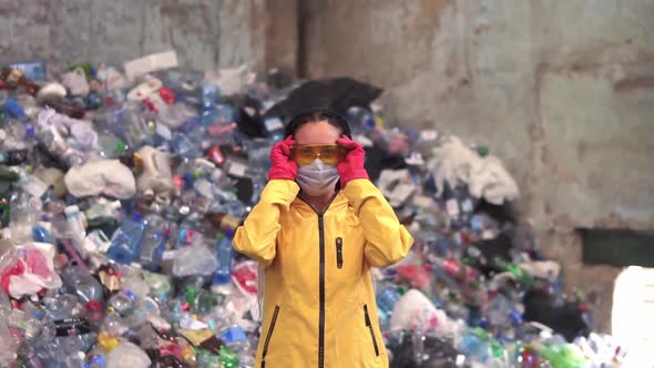 Portrait of Young Woman Worker in Red Rubber Gloves Putting on a Mask and Protective Eyeglasses