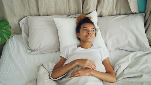 Pretty Mixed Race Lady Is Lying in Bed and Sighing Looking at Ceiling Then Closing Her Eyes