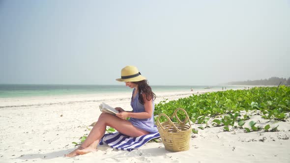 Young Caucasian Woman Reading Book On The Beach