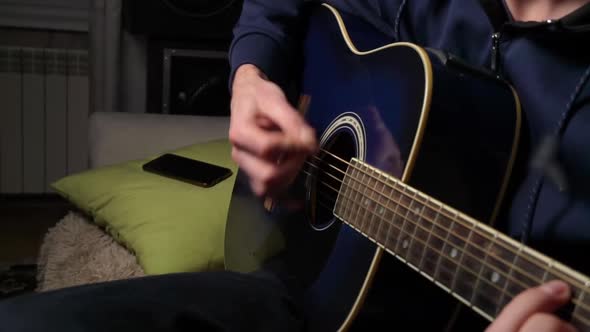 Man Plays a Pick on a Modern Guitar in the Dark Slow Mo