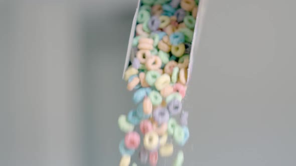 Breakfast Cereals in the Form of Colorful Corn Rings are Poured Out of the Package