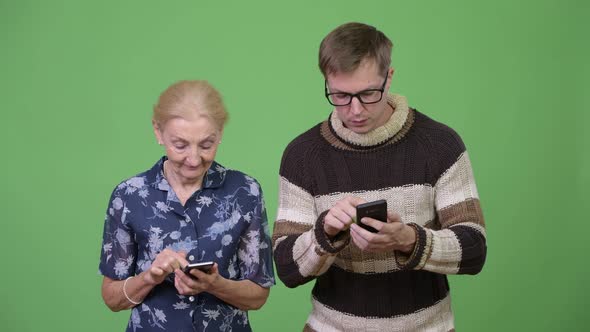 Happy Grandmother and Grandson Using Phone and Talking Together