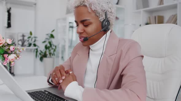 Young Hispanic Business Woman Wearing Headset Communicating By Video Call