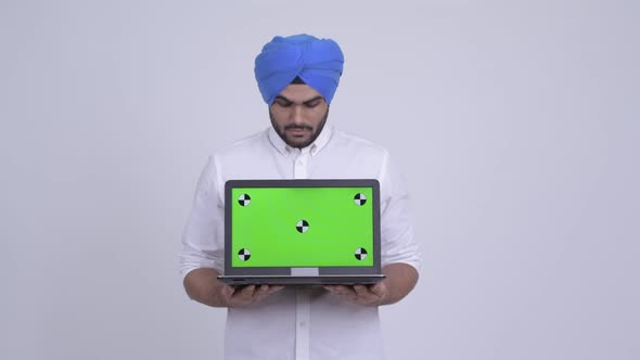 Happy Young Bearded Indian Sikh Man Showing Laptop
