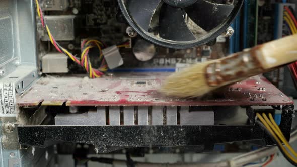 Unrecognizable Master Brushing a Disassembled Dusty Computer with a Brush Closeup