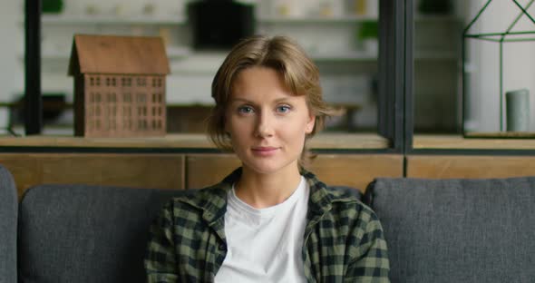 Portrait of Young Happy Woman, Sitting on Sofa at Home