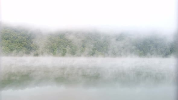 Morning fog over a calm lake. View from a slow floating pair.