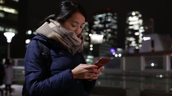 Woman using cellphone at night