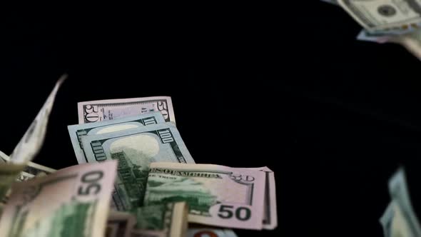 Heaps Of USD Bills Falls From Above On Black Table. - studio shot