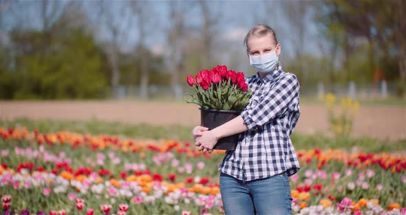 Woman Holding Tulips Bouquet in Hands While Walking on Tulips Field