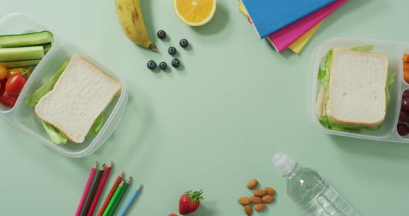 Video of healthy packed lunch of fruit and vegetables, with coloured pencils and notebooks