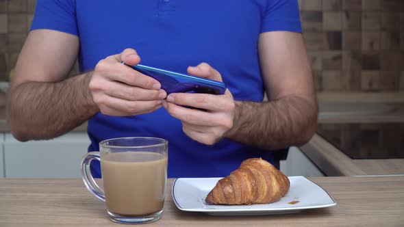 Man Plays a Mobile Video Game Using a Smartphone