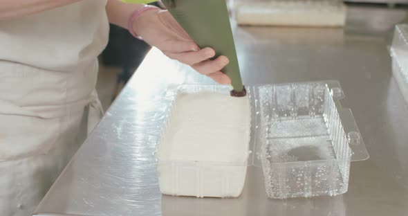 Slow motion - Baker spreading Blueberry jam over a cheese cake