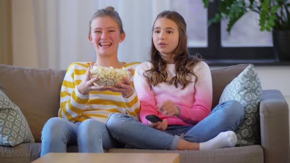 Teenage Girls Eating Popcorn Watching Tv at Home