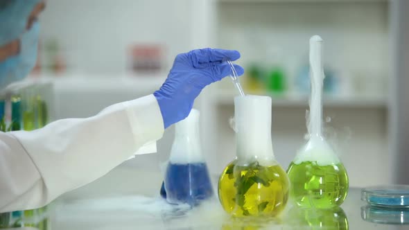 Biochemist Taking Yellow Organic Substance Sample From Flask, Plant Extraction