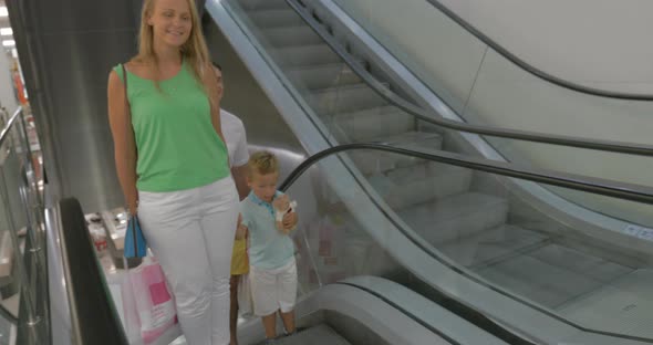 Smiling Family on the Escalator after Shopping