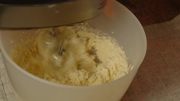 Unrecognizable Person Whisks Dough in Bowl with Mixer