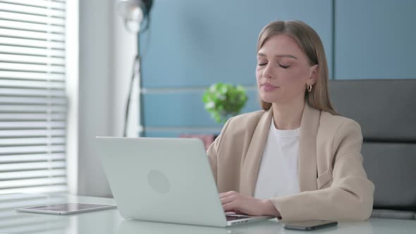 Businesswoman Shaking Head As No Sign While Using Laptop in Office