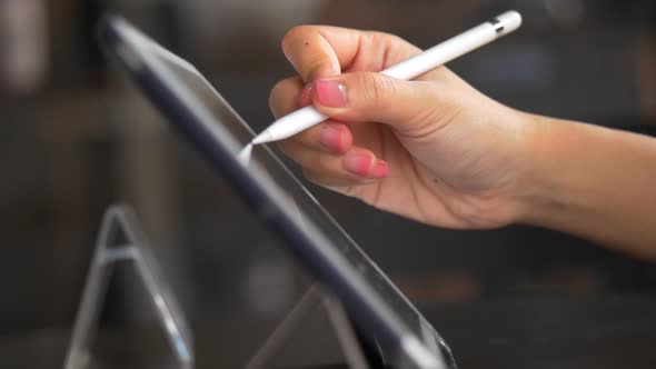 Close Up hands using drawing on a tablet in the coffee shop.