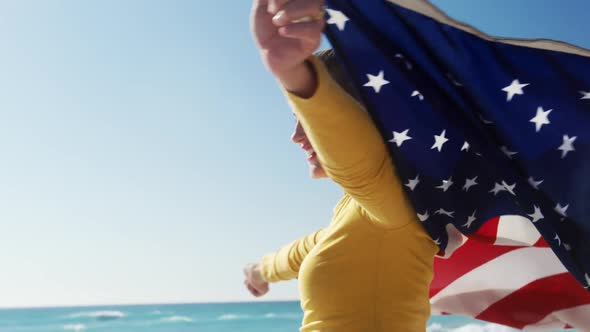 Woman holding American flag on the beach