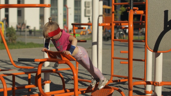 Young Girl in Sportswear Making Push-ups Exercises on Playground. Workout for Kids. Athletic Child