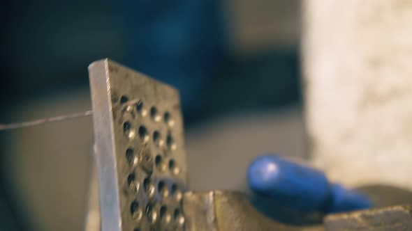 Silversmith Pulls Wire Through Tool with Pliers Close View