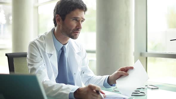Doctor talking with out-of-frame patient in office