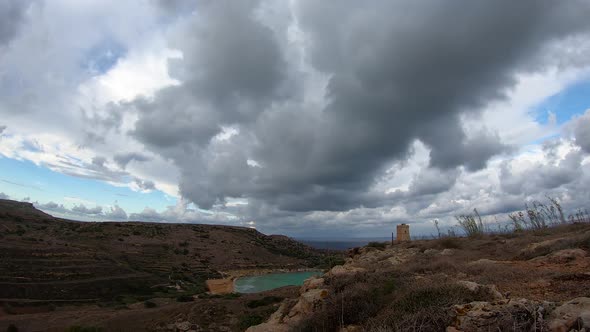 Dramatic big dark clouds over the Lippija tower and Gnejna bay timelapse