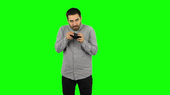 Brunette Guy Is Playing a Video Game Using a Wireless Controller and Loses. Green Screen