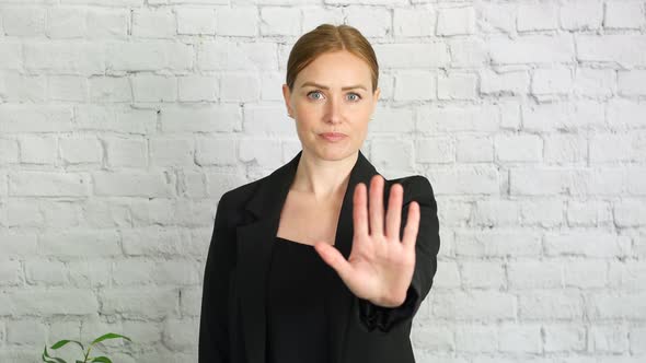 Woman gesturing to stop with hand movement. The businesswoman is unhappy and is signalling with a st