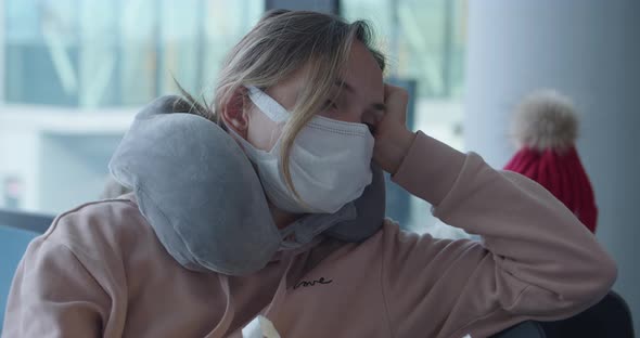 Bored Woman in Mask with Travel Pillow Waits for Flight