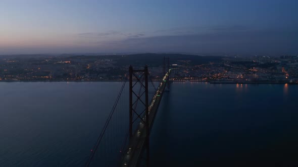 Aerial Night Orbit of Ponte 25 De Abril Red Bridge with Car Traffic and Lights Off the Coast of