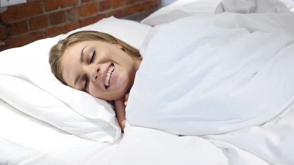 Young Woman Falling Asleep in Bed at Night