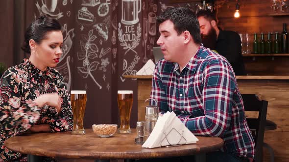 Couple in Vintage Rustic Pub Restaurant Drinking Beer