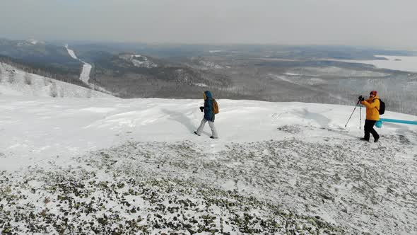 Man and Woman are Walking Along Path on the Top of Snowcovered Hill