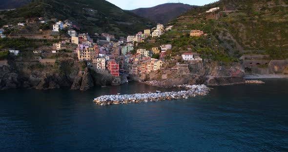 Aerial shows colorful facades of houses on terraced hillside; Riomaggiore