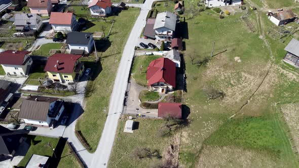 Charming detached houses along road, Lasko, Slovenia. Aerial forward