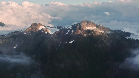 Aerial Mountain Range in Snowy Cold Winter in Golden Sunset Light Pink Sunrise