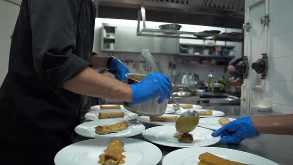 Chef preparing crepes on plates in restaurant kitchen