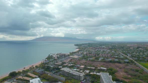 Orbital drone footage of beach at Hawaii looking at volcano.