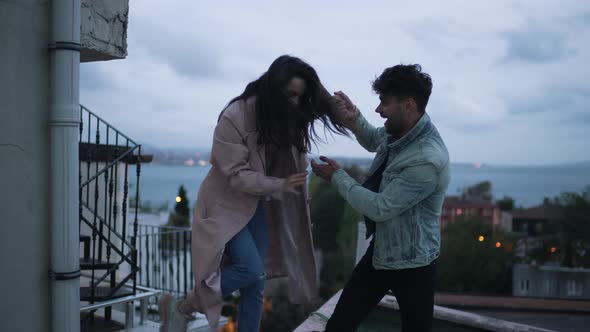 Couple Climbed to the Roof Against the Backdrop of the City