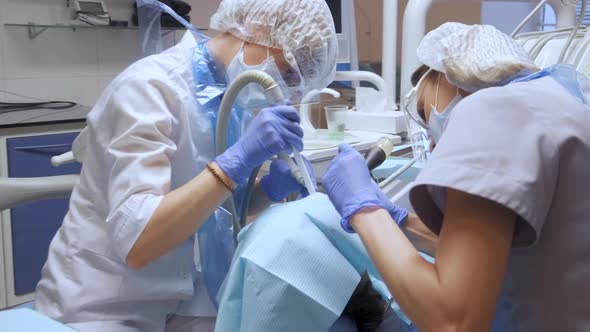 Two Young Female Dentist Doctor In Face Protection Is Performing Surgery In A Hospital 