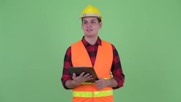 Happy Young Multi Ethnic Man Construction Worker Talking While Holding Clipboard