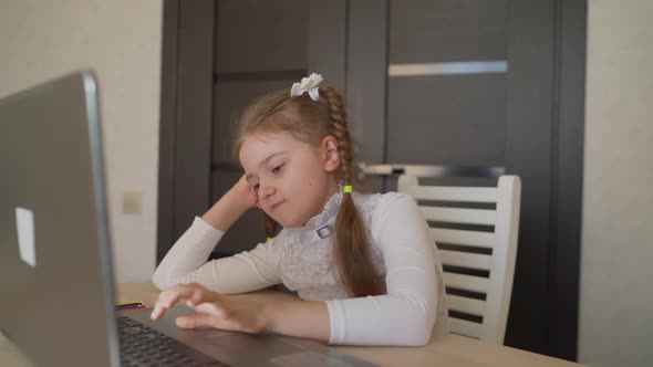 Girl Schoolgirl Sitting at Home with a Laptop