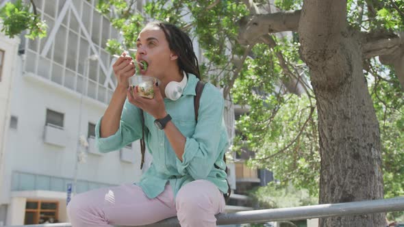 Mixed race man eating outside