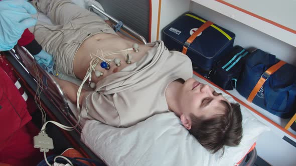 A Young Man is Being Prepared for Resuscitation in an Ambulance