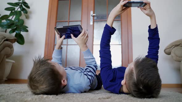 Two child using a smartphone at home. Child playing video game at home