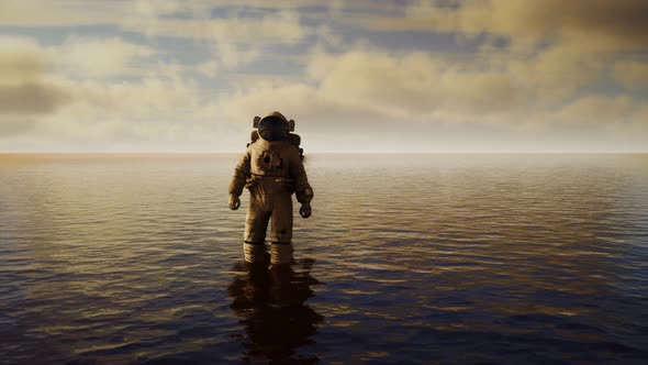 Spaceman in the Sea Under Clouds at Sunset