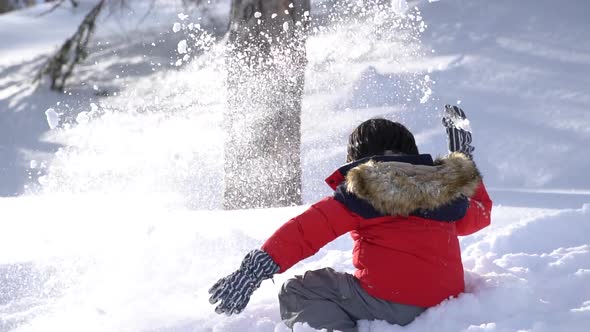 Cute Asian Child Wearing Winter Clothes Playing On Snow In The Park