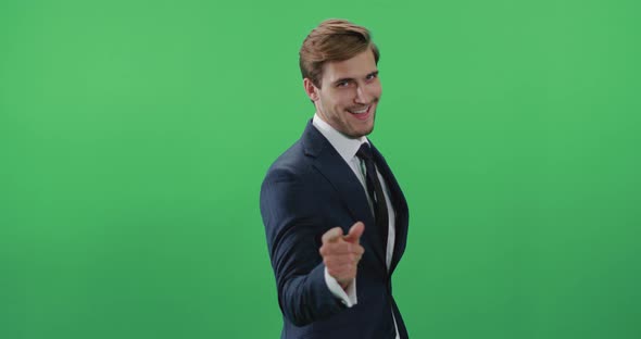 Businessman in a Suit Standing in Green Room and Looks at the Camera, Chroma Key Background, the Man